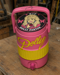 Pink 3D-printed Dolly Parton tribute coozie with RIP Dolly Parton lid graphic on a wooden workbench