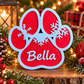Red and white 3D-printed paw print Christmas ornament with snowflakes and the name Bella