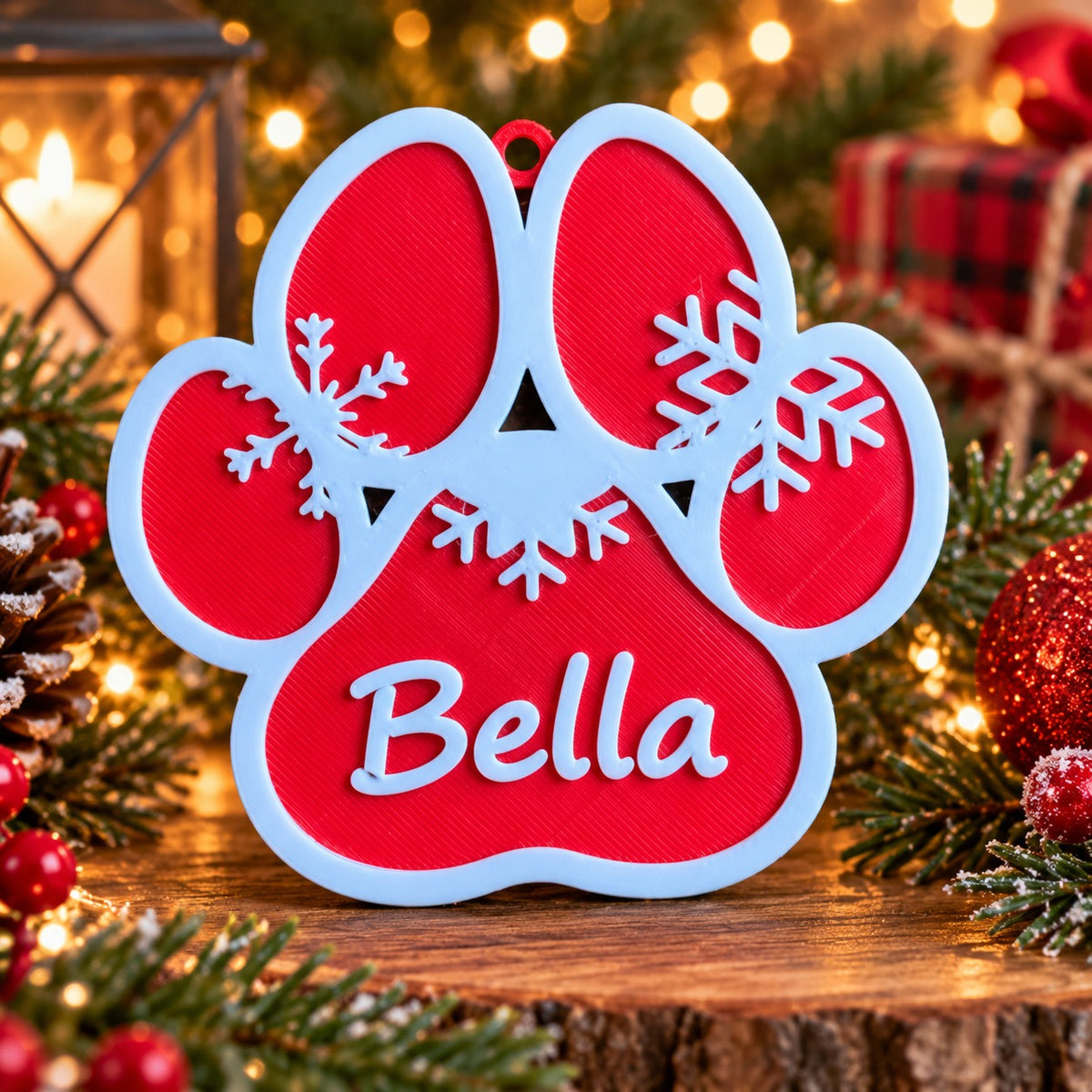 Red and white 3D-printed paw print Christmas ornament with snowflakes and the name Bella